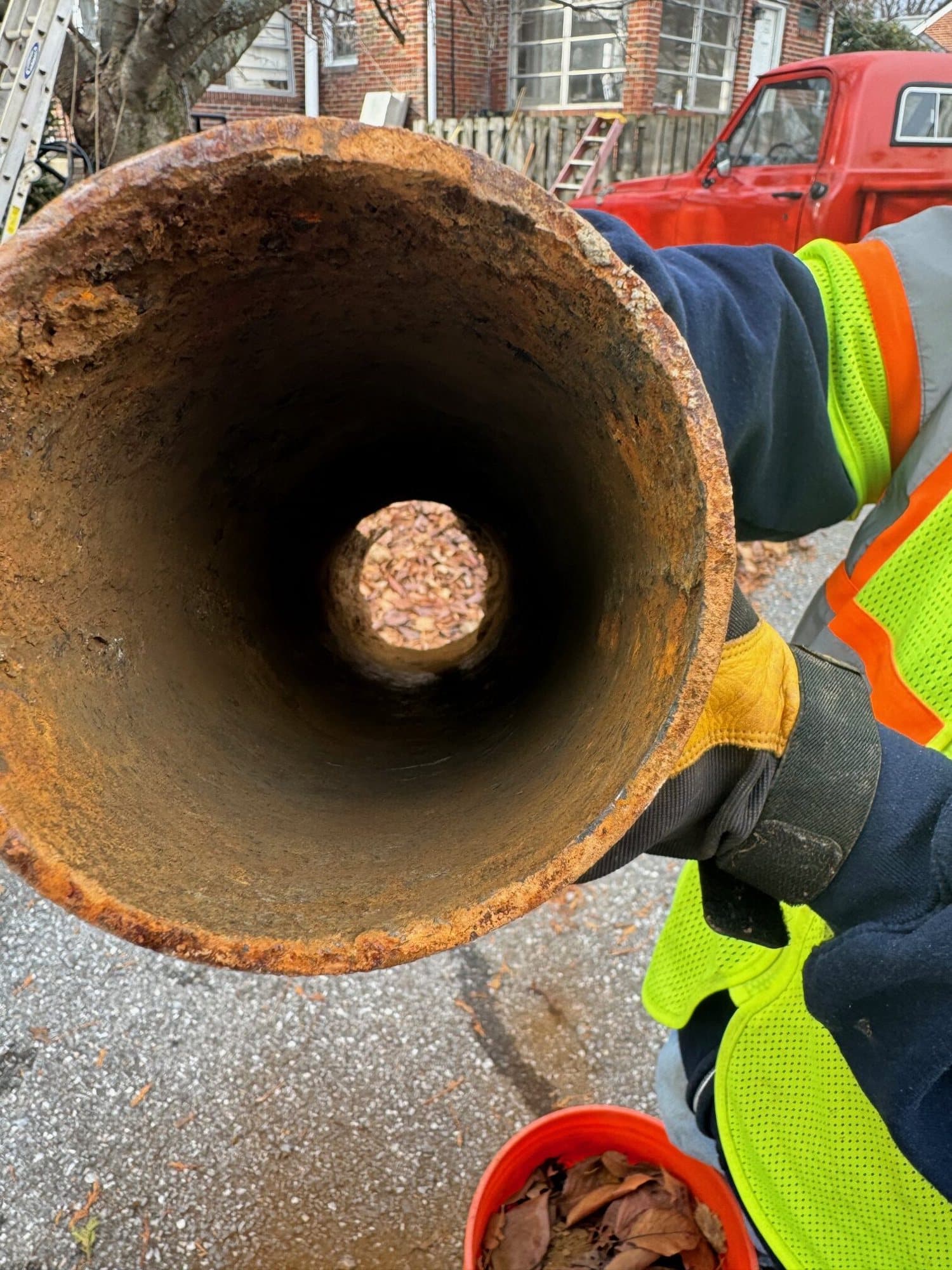 Technician holding a cut section of old cast iron pipe showing a clean bore after descaling